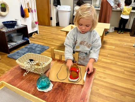 Toddler cleaning shoes at Lifetime Montessori School in San Diego