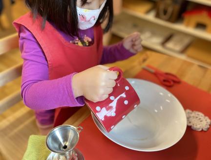 Child cutting fruit independently at Lifetime Montessori school in Santaluz