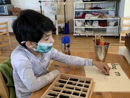 Elementary Montessori Child Working on Writing Skills Independently