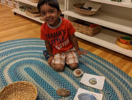 Toddler boy mastering shapes in a Montessori classroom