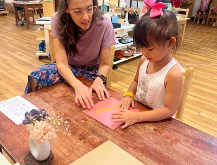 Montessori guide and Transitional Kindergarten child working together
