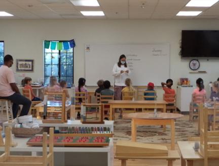 Montessori Teacher noticing the classwork children are working on