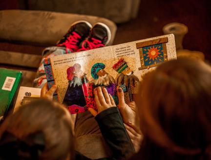 Mother and child reading a book together on the couch