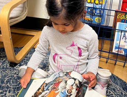 Preschooler learning how to read a book at Lifetime Montessori school in San Diego