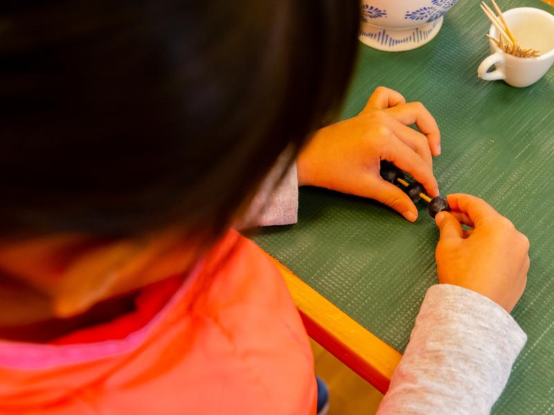 Girl placing blueberries in toothpick