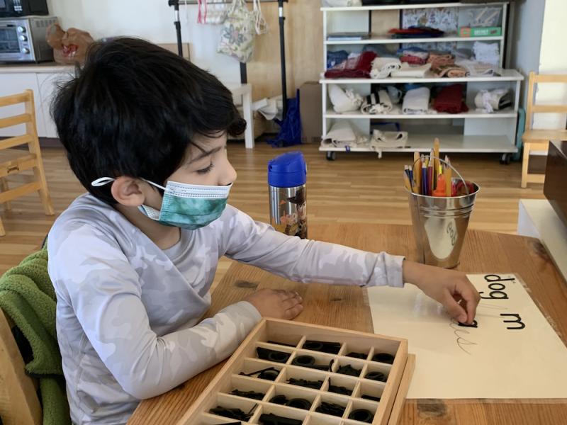 Elementary Montessori Child Working on Writing Skills Independently