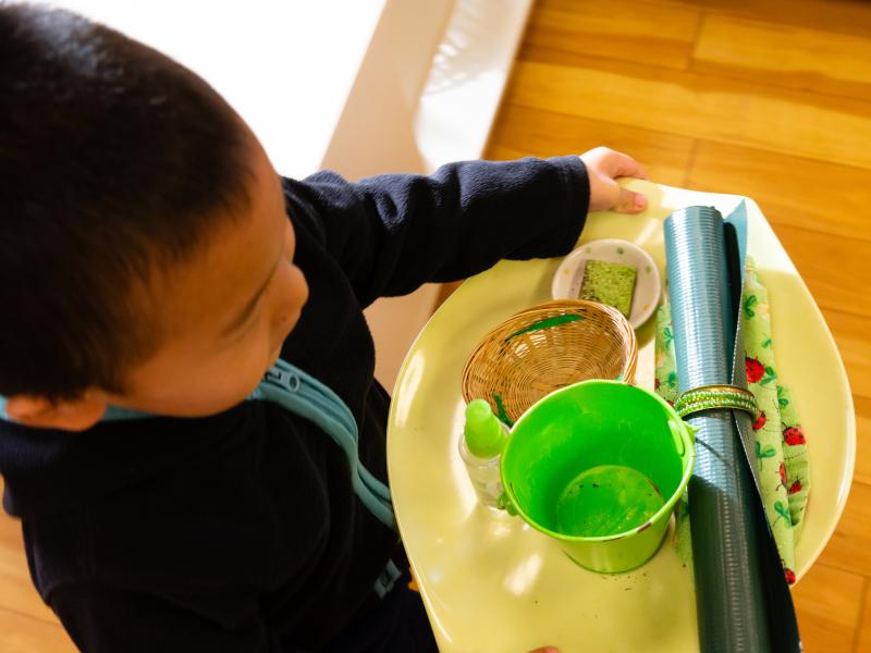 Boy carrying his plate sitting in a Montessori classroom