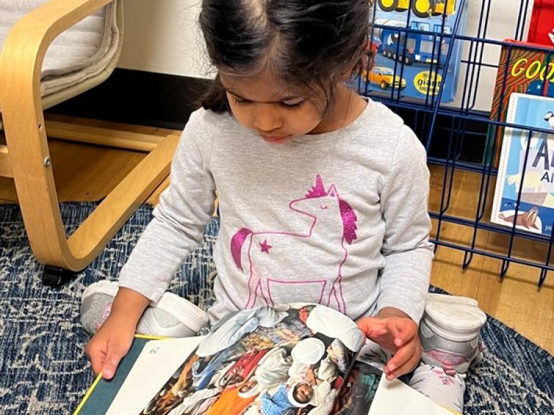 Preschooler learning how to read a book at Lifetime Montessori school in San Diego