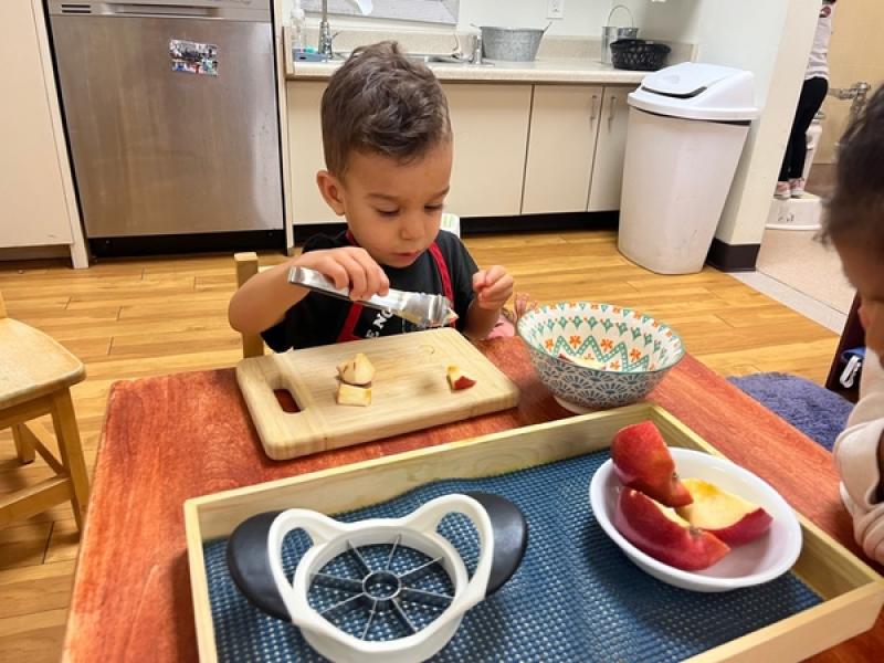 Child making breakfast independently at Lifetime Montessori school in Santaluz