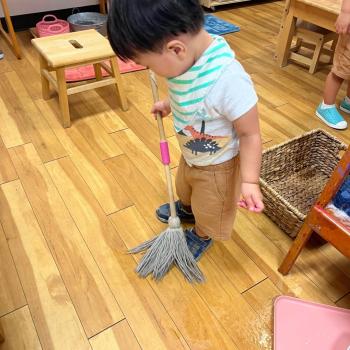 Toddler mopping his space at Lifetime Montessori School