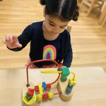 Toddler independently learning shapes and puzzles at Lifetime Montessori School 