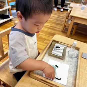 Toddler independently painting at Lifetime Montessori School 