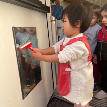 Toddler independently cleaning with a squidgy at Lifetime Montessori School 
