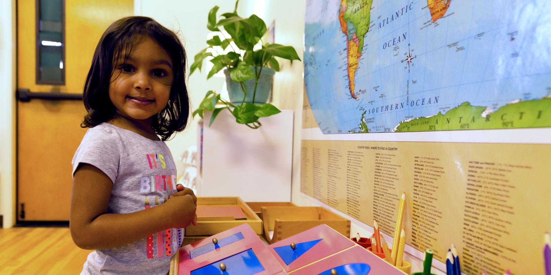 Girl in her Montessori Primary classroom learning how to write in Spanish